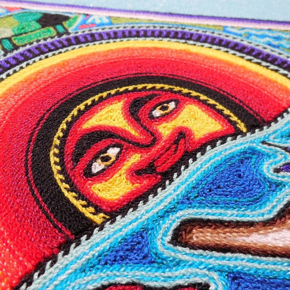 Close-up of sun god symbol in Huichol nierika yarn artwork