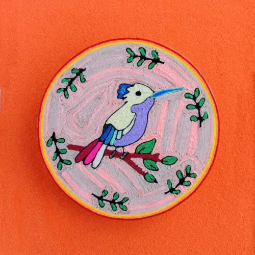 Handmade Huichol yarn painting featuring a colorful hummingbird on a branch, crafted with yarn and beeswax on a 20cm round wooden base.