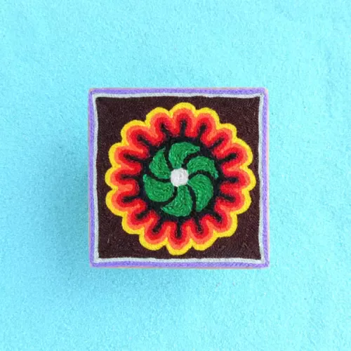Handmade Huichol yarn painting showing a green peyote flower with red and yellow patterns, crafted with yarn and beeswax on a 10cm square wooden base. Front Image