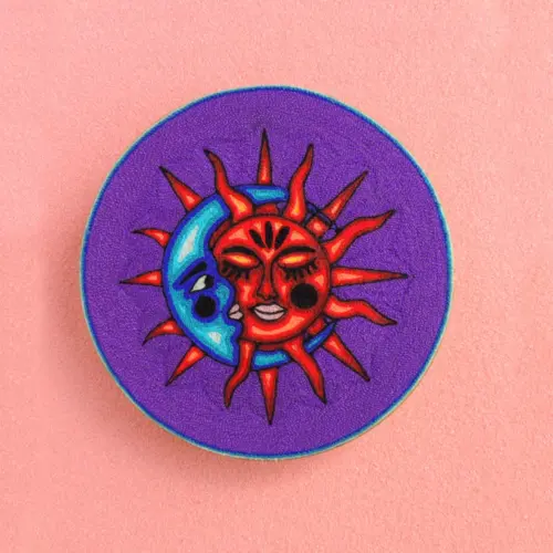 Handmade Huichol yarn painting showing the sun and moon meeting in an eclipse on a purple background, crafted with yarn and beeswax on a 20cm round wooden base. Front Image