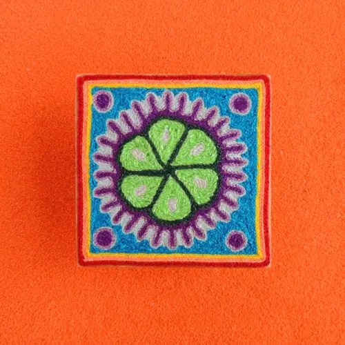 Handmade Huichol yarn painting showing a green peyote design with purple dots and a blue border, crafted with yarn and beeswax on a 10cm square wooden base. Front Image
