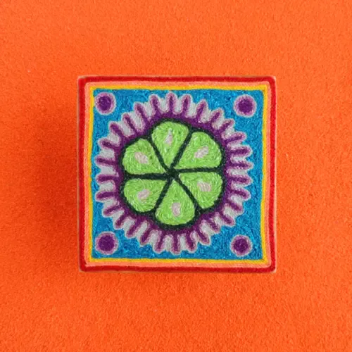 Handmade Huichol yarn painting showing a green peyote design with purple dots and a blue border, crafted with yarn and beeswax on a 10cm square wooden base. Front Image