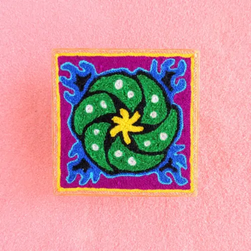 Front view of a 10 cm Huichol yarn painting with green peyote and yellow flame