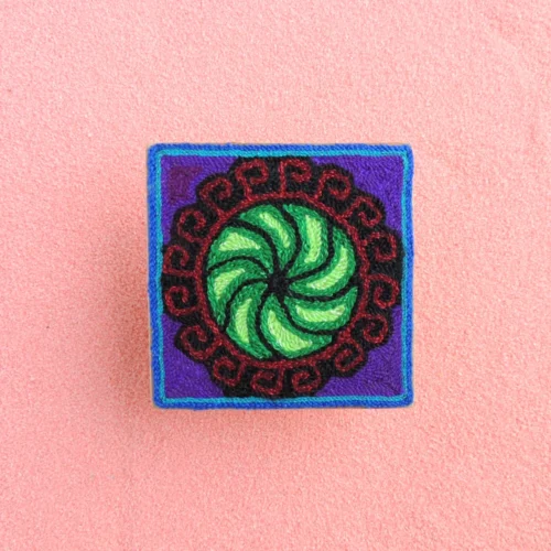 Front view of green spiral peyote Huichol yarn painting