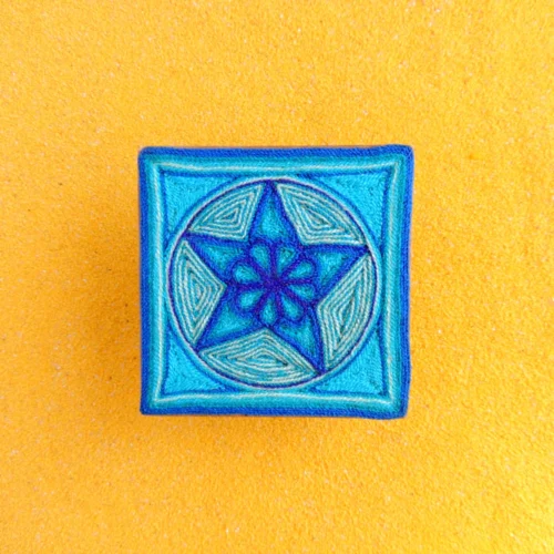 Front view of Huichol yarn painting with blue peyote star design